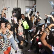 Private party DJ mixing music while guests dance