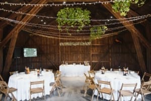 Polished DJ setup for rustic venue DJ booth with lighting and speakers at a Woodbury wedding