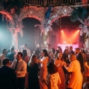 Packed wedding dance floor with energetic guests and DJ