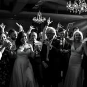 Packed wedding dance floor with guests dancing to popular songs