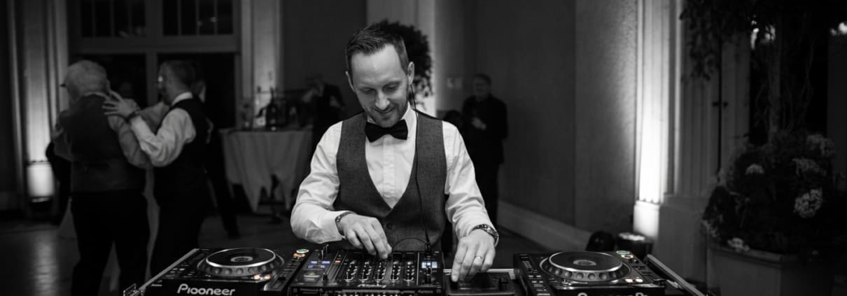 Professional DJ setup with newlyweds dancing nearby