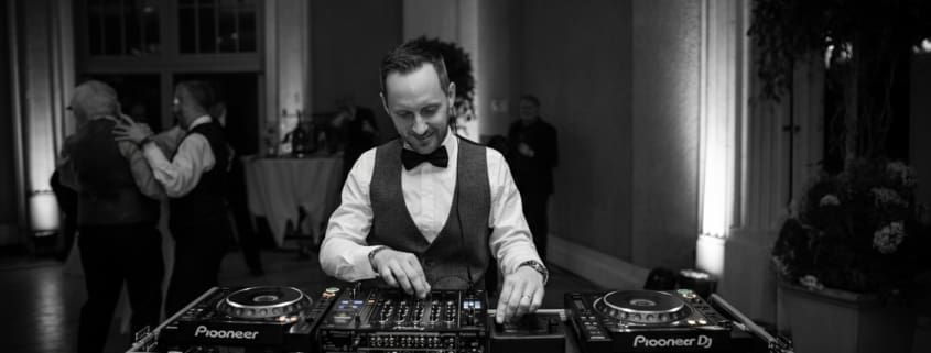 Professional DJ setup with newlyweds dancing nearby